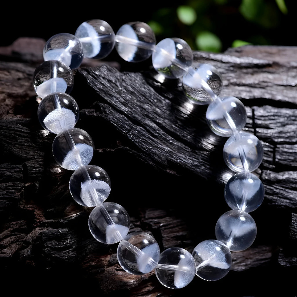 Women's white crystal bracelet with a ghost pyramid charm and Ruyi symbol, showing round beads.