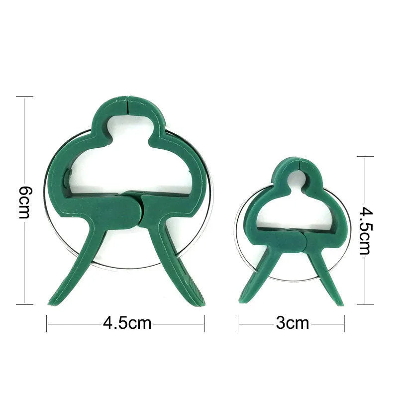 Green plastic and zinc plant fixing clips for supporting tomato vines and climbing plants in the garden.