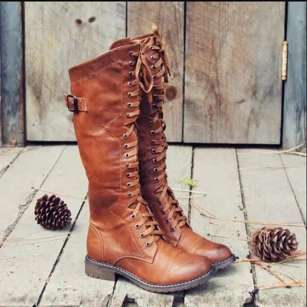 Women's black high leg boots with a round toe and low chunky heel on a plain background