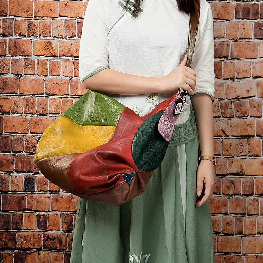 Brown cowhide leather travel shoulder bag with stitching detail, shown with a laptop and tablet inside.