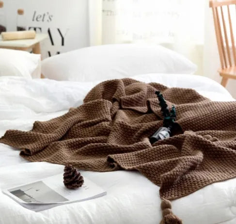 Nordic fringed knit ball acrylic blanket in beige colour on sofa