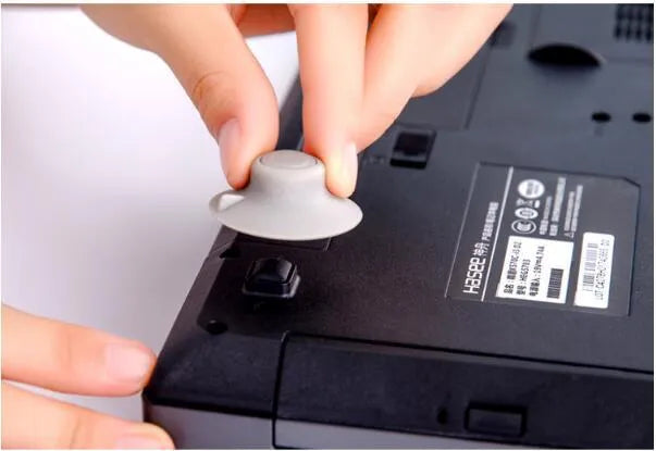 Set of four grey durable plastic laptop cooling pads: two large and two small, on a desk.
