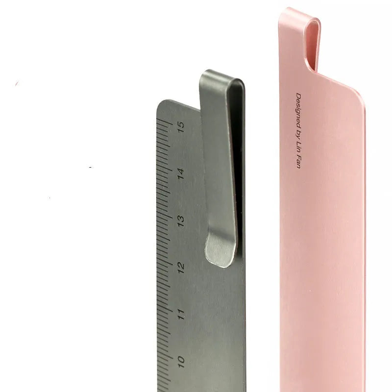 RUMA black and silver aluminium bookmark ruler showing 15cm laser-engraved scale.
