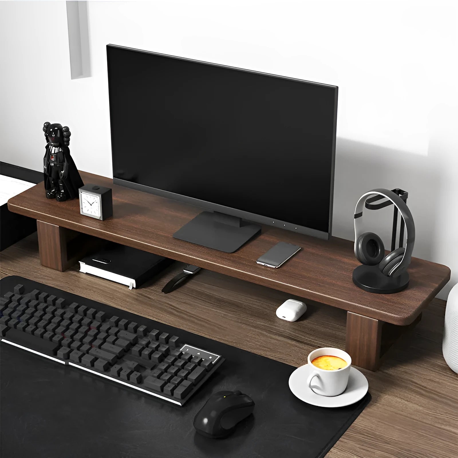 Solid walnut wood computer monitor heightening frame on a wooden desk with a keyboard stored below