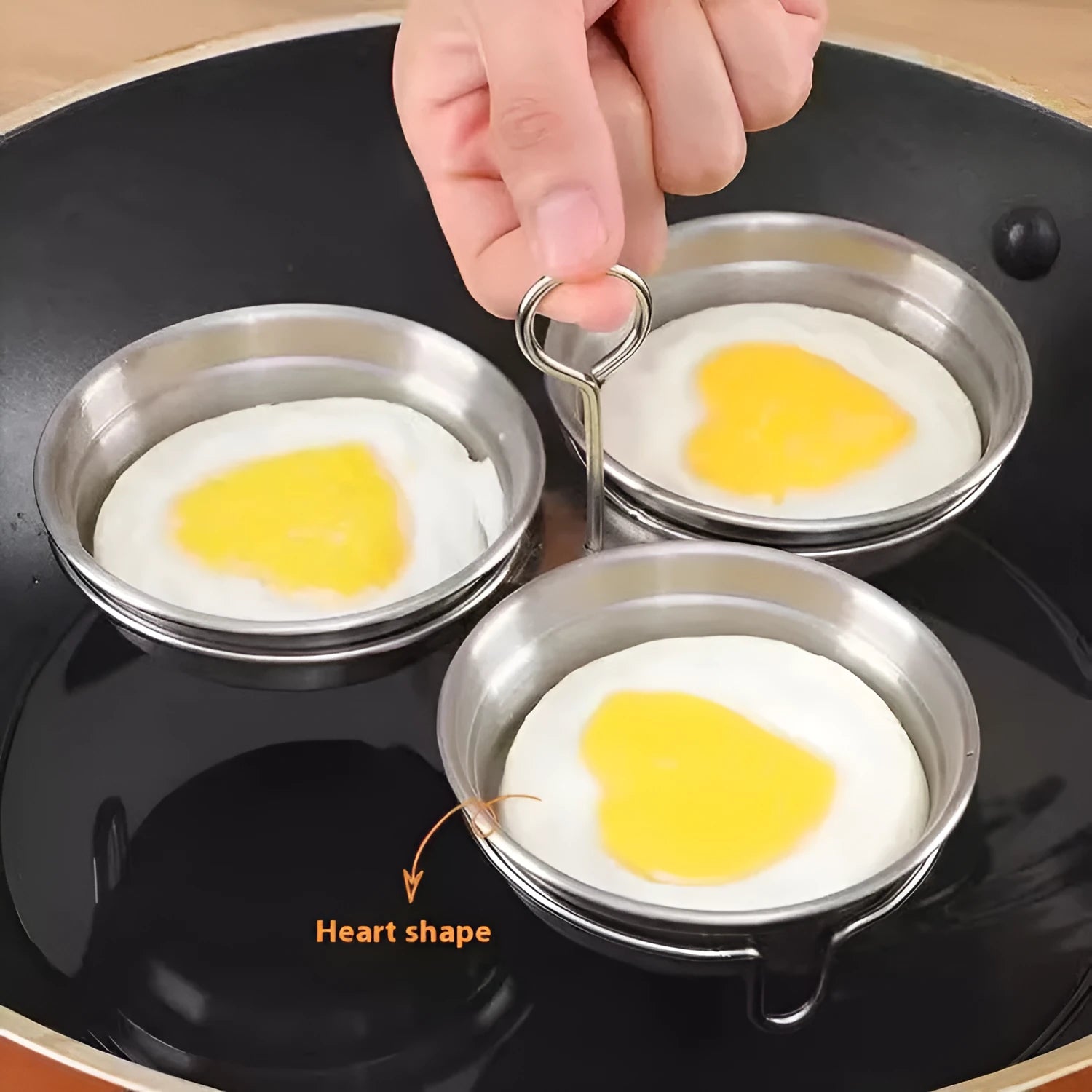Mini stainless steel egg steamer showing both round and heart-shaped design options on a kitchen counter.