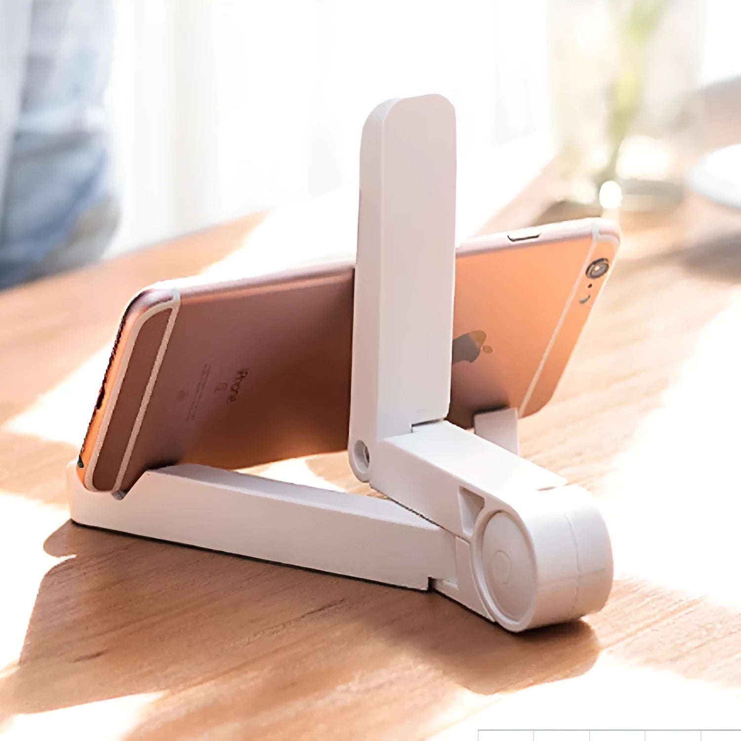Black foldable tablet holder stand supporting a smartphone in landscape mode on a desk.