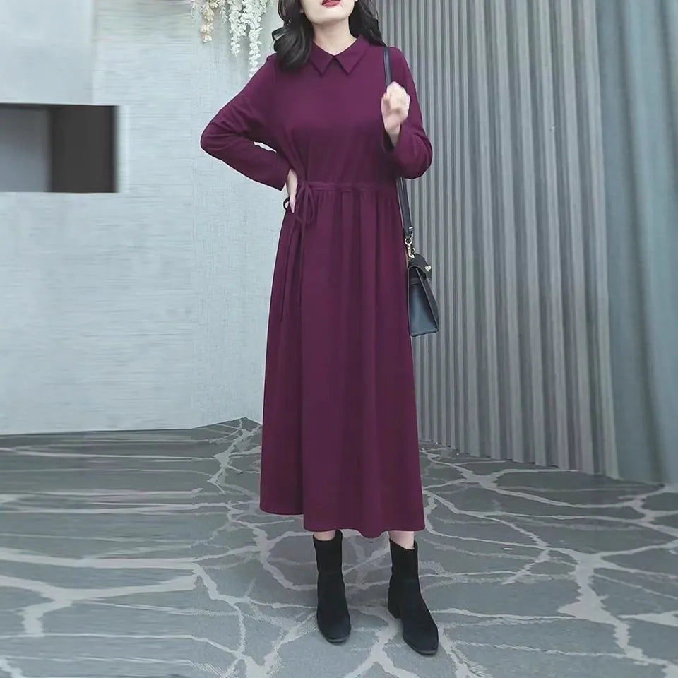 Purplish red long sleeve dress for women on a hanger, showing long skirt and extra long sleeves.
