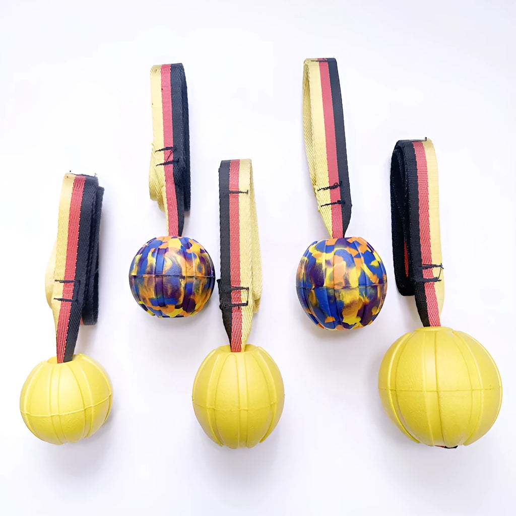 Yellow and camouflage coloured EVA foam floating dog tether balls in three different sizes on a blue background.