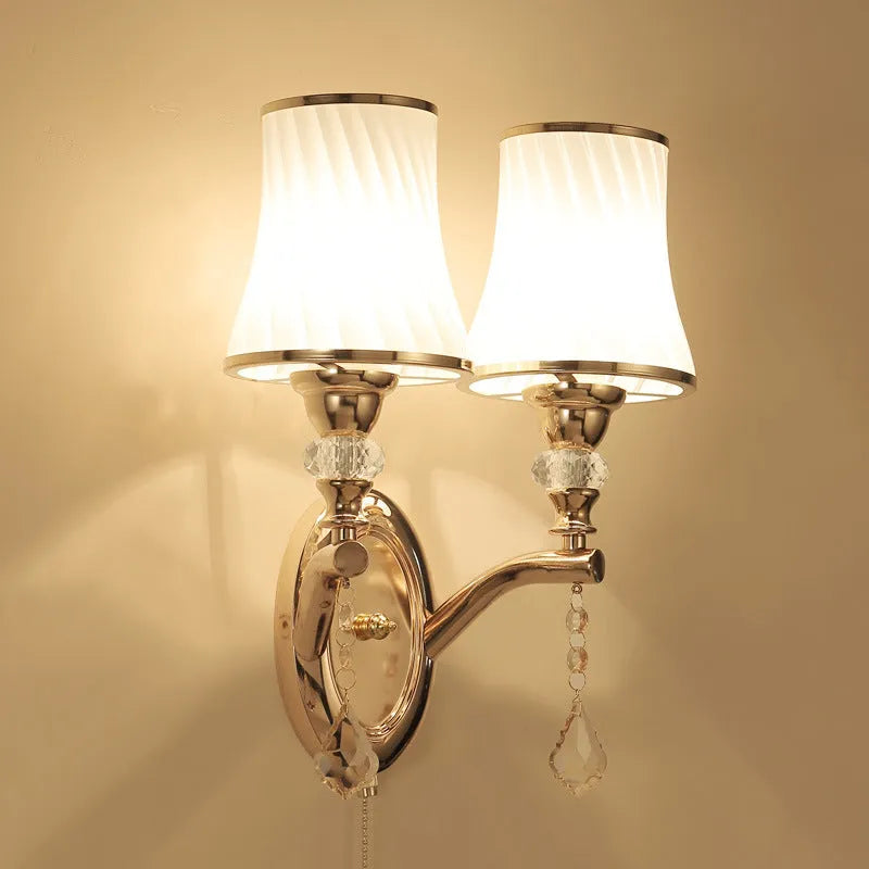 European style glass wall lamp with a fabric cable switch, shown in a bedroom setting.