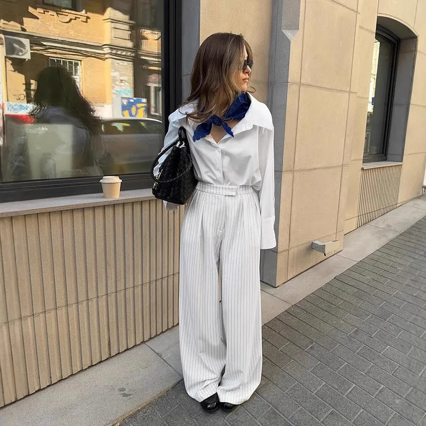 Women's white striped wide-leg trousers with front zipper closure on hanger