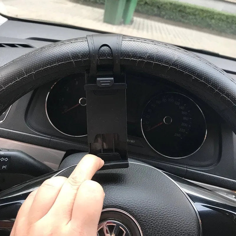 Black universal steering wheel phone holder clip mounted on a car steering wheel with a smartphone secured.