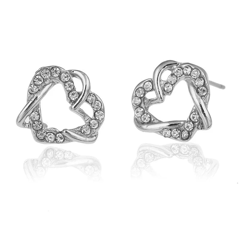 Gold colour alloy heart-shaped stud earrings on white background