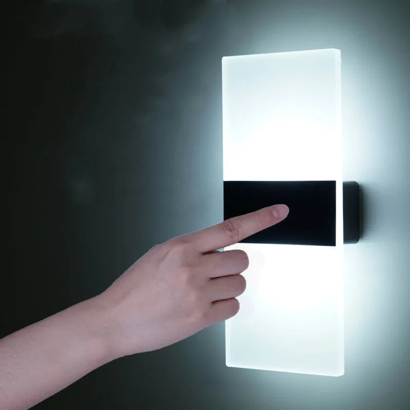 Magnetic rechargeable wall lamp in arc style, black finish, with warm light on a metal bedside shelf
