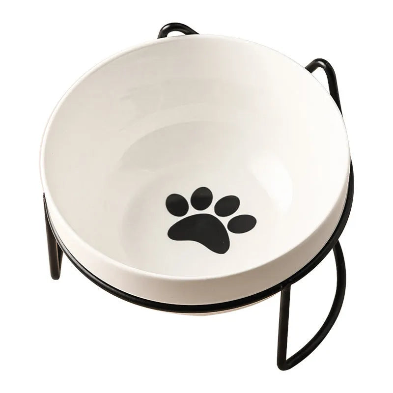 White ceramic pet bowl with cat footprints design in a black iron frame.