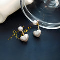 Heart-shaped pearl stud earrings with alloy settings and electroplated metallic finish