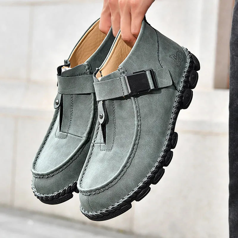 Black handmade stitching flat bottom slip on lazy shoes with low heel on a plain background