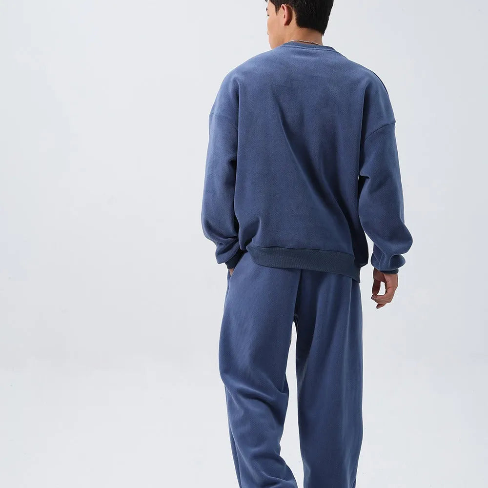 Men's polar fleece tracksuit set showing crew neck top with padded trousers in winter sportswear style