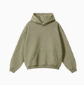 Man wearing a grey heavyweight cotton terry hooded sweater with a loose fit and drop-shoulder sleeves.