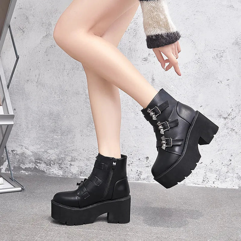 Black women's punk-style Martin ankle boots with a bat-shaped buckle and side zipper.
