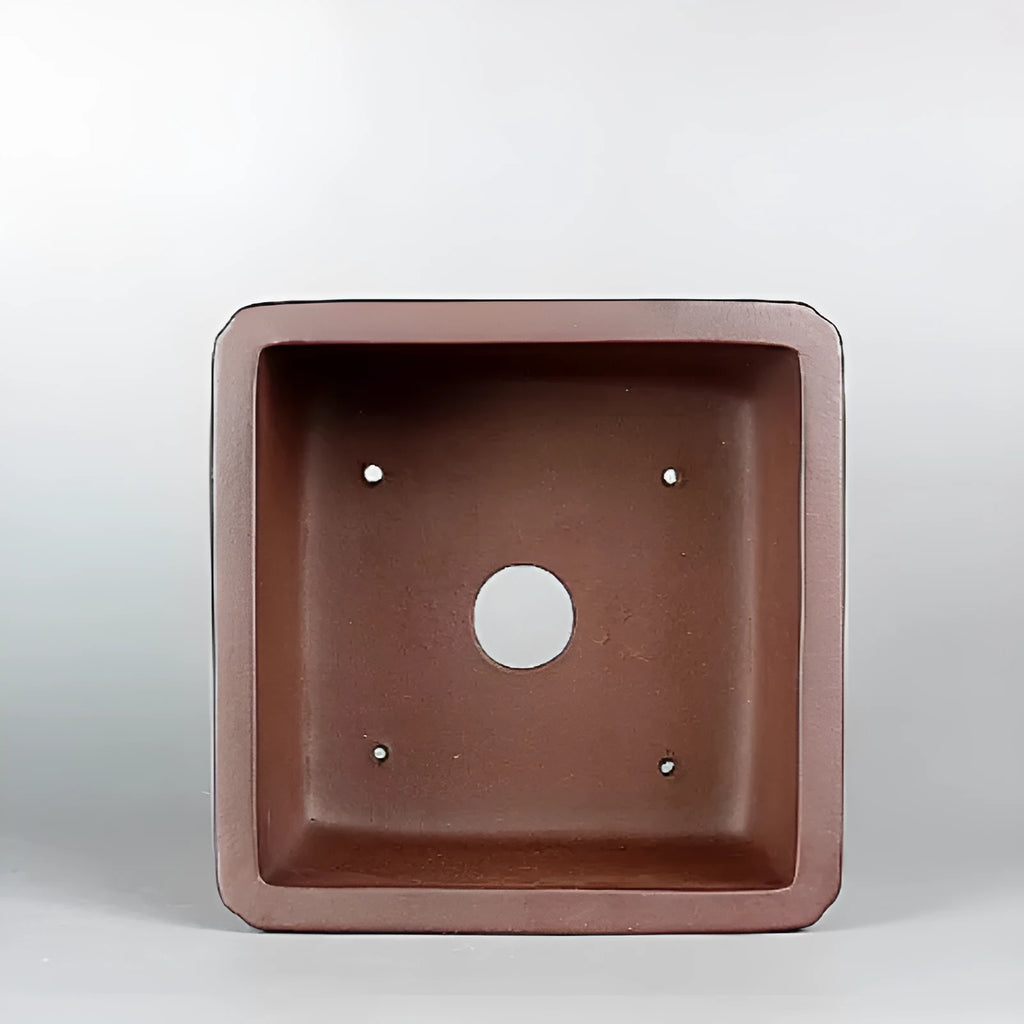 Brown handmade purple clay ceramic flower pot with antique style, shown on a surface.