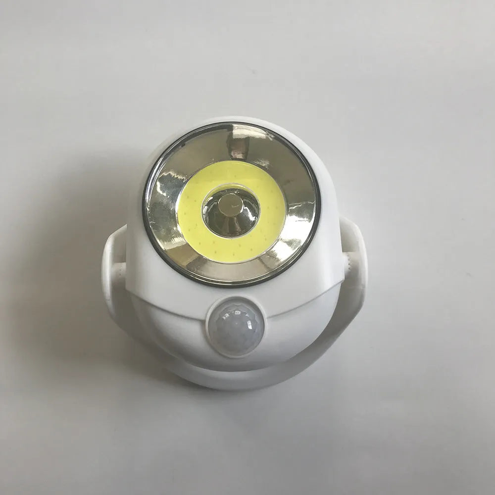 White Atomic Angel induction light lamp on a surface showing its compact size.