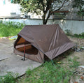 Brown or white A-line pole-free cabin tent for hiking, shown packed and pitched.