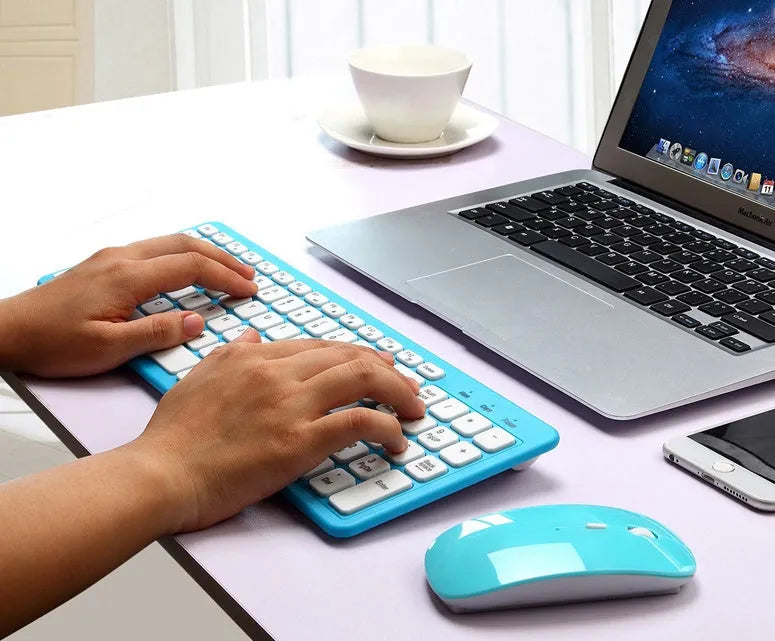 Black wireless keyboard and mouse set with USB receiver on a wooden desk