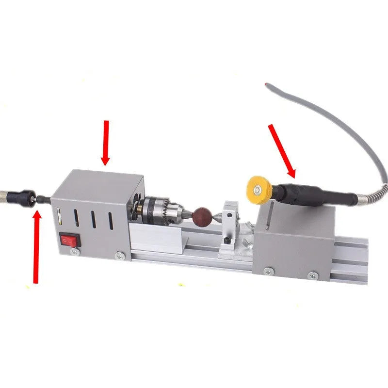 Mini metal woodworking lathe with silver finish and carving accessories on workbench