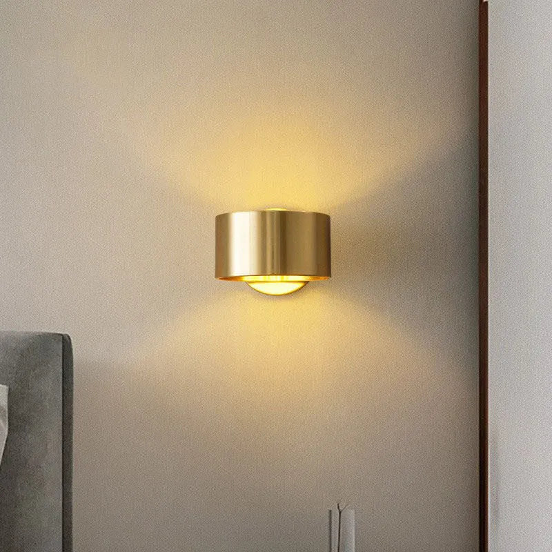 Modern copper wall light fixture in gold finish mounted on a wall