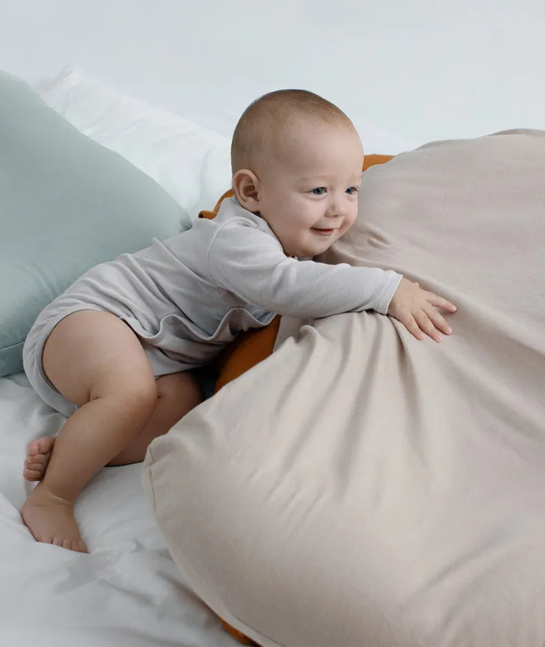 Beige portable baby nest crib for newborns measuring 75cm by 45cm on a neutral background.