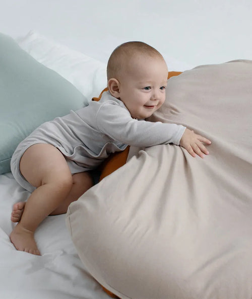 Beige portable baby nest crib for newborns measuring 75cm by 45cm on a neutral background.