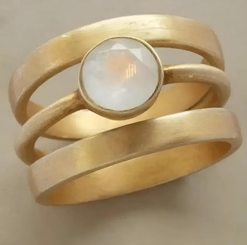 Gold titanium steel geometric ring with micro-inlaid white chalcedony stones on a hollow band.