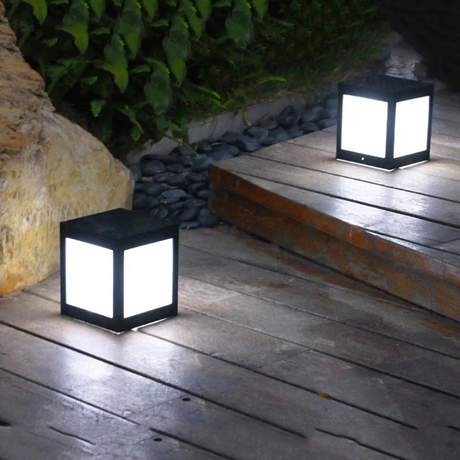 Set of solar-powered waterproof garden lights installed along a lawn edge and on a wall.