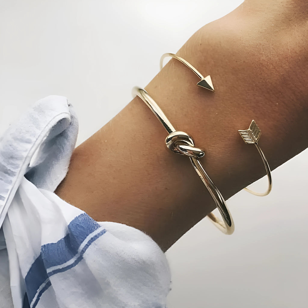 Gold vintage women's cuff bracelet with arrow and knotted design details.