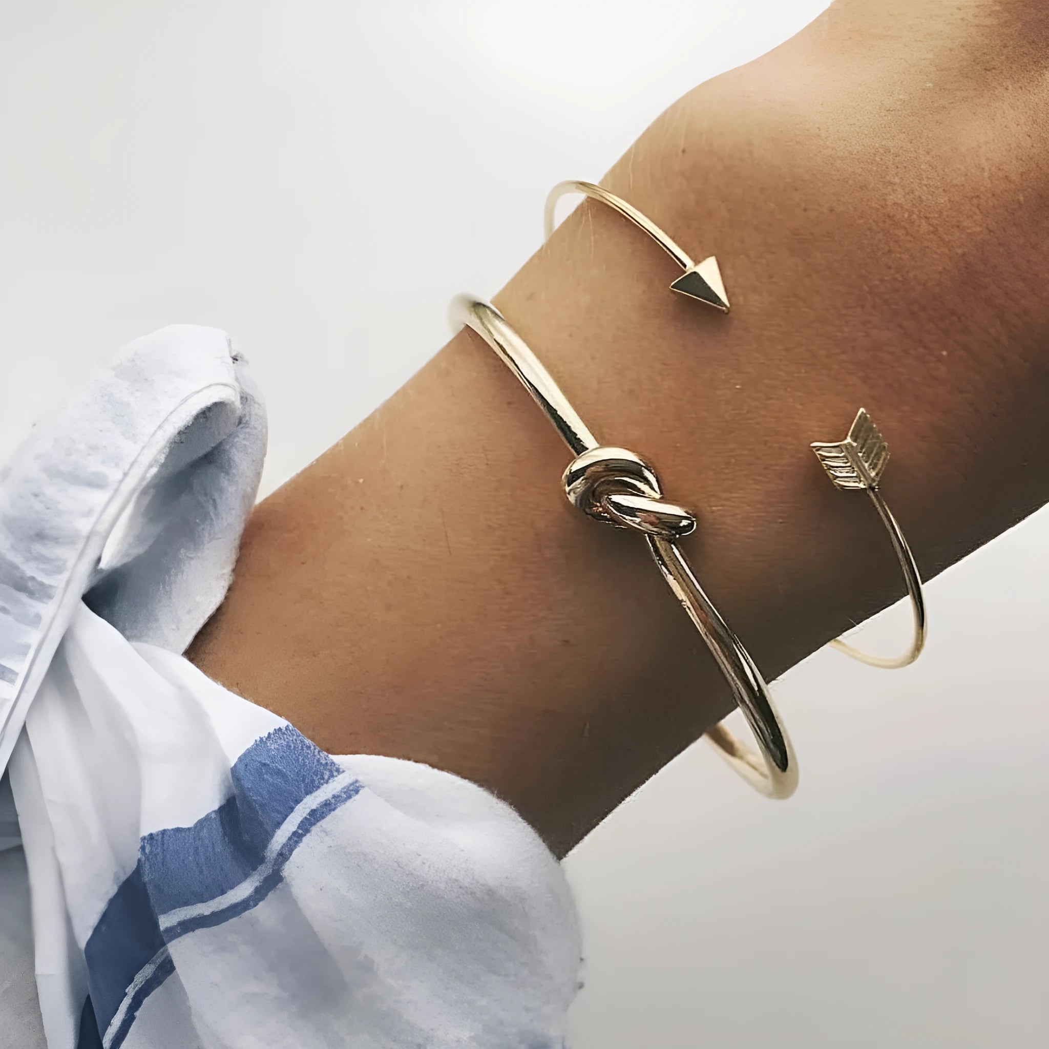Gold vintage women's cuff bracelet with arrow and knotted design details.