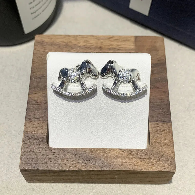 Diamond studded women's light luxury rocking horse drop earrings in gold colour on display