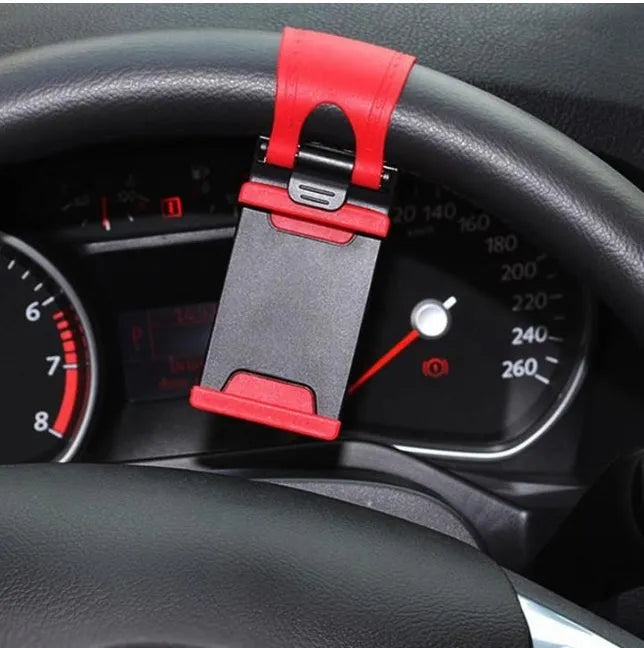 Black universal steering wheel phone holder clip mounted on a car steering wheel with a smartphone secured.