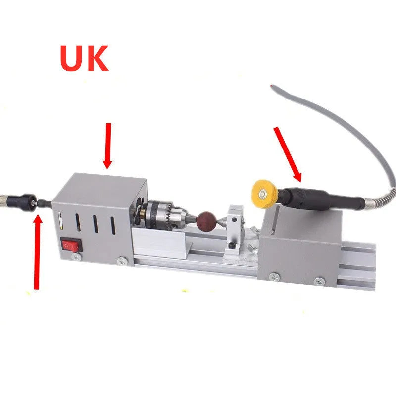 Mini metal woodworking lathe with silver finish and carving accessories on workbench