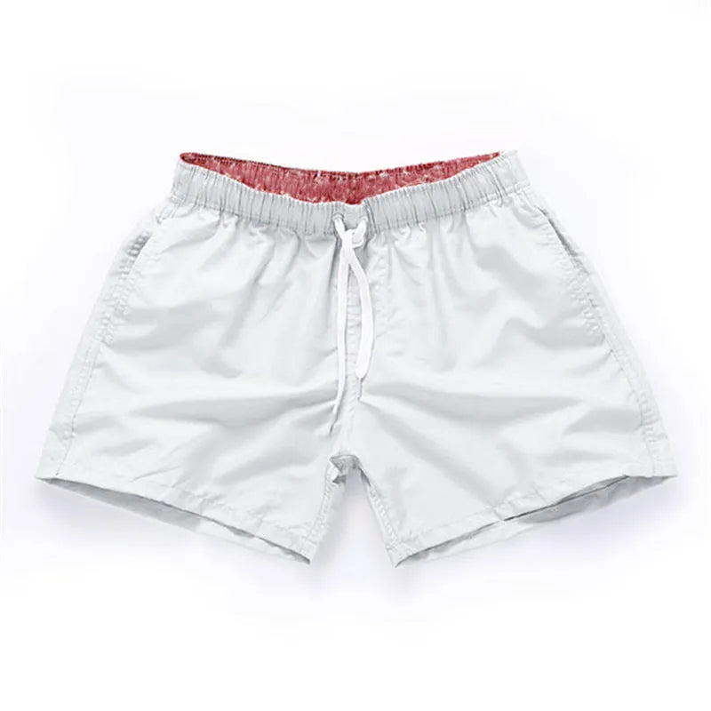 Men's straight-leg beach shorts in polyester fabric on a beach background