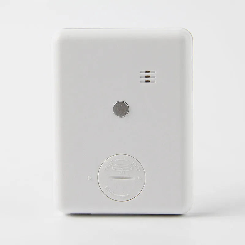 Black and white mechanical kitchen timer with magnetic back showing 60-minute dial.