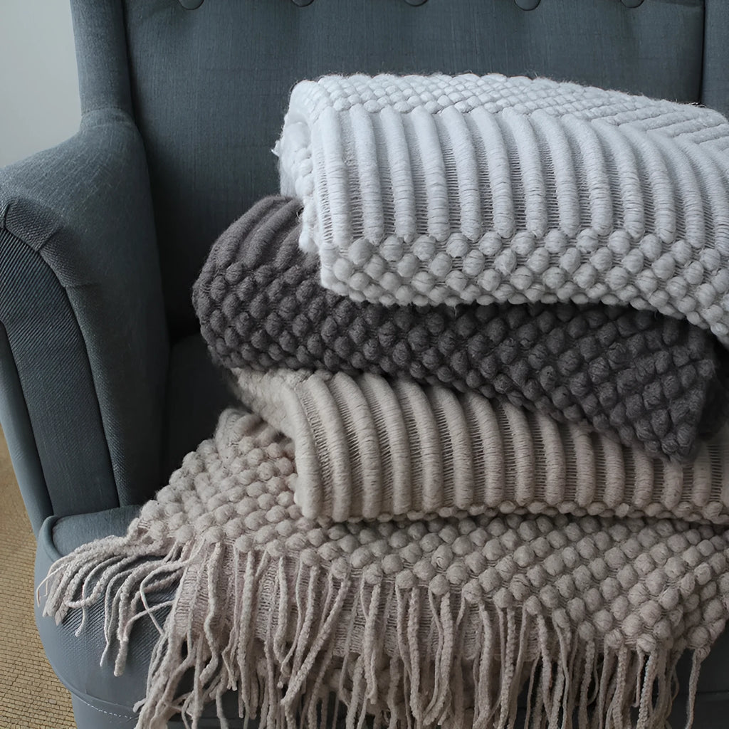Small polyester blanket in dark grey, khaki or light grey colours measuring 127 by 170 centimetres