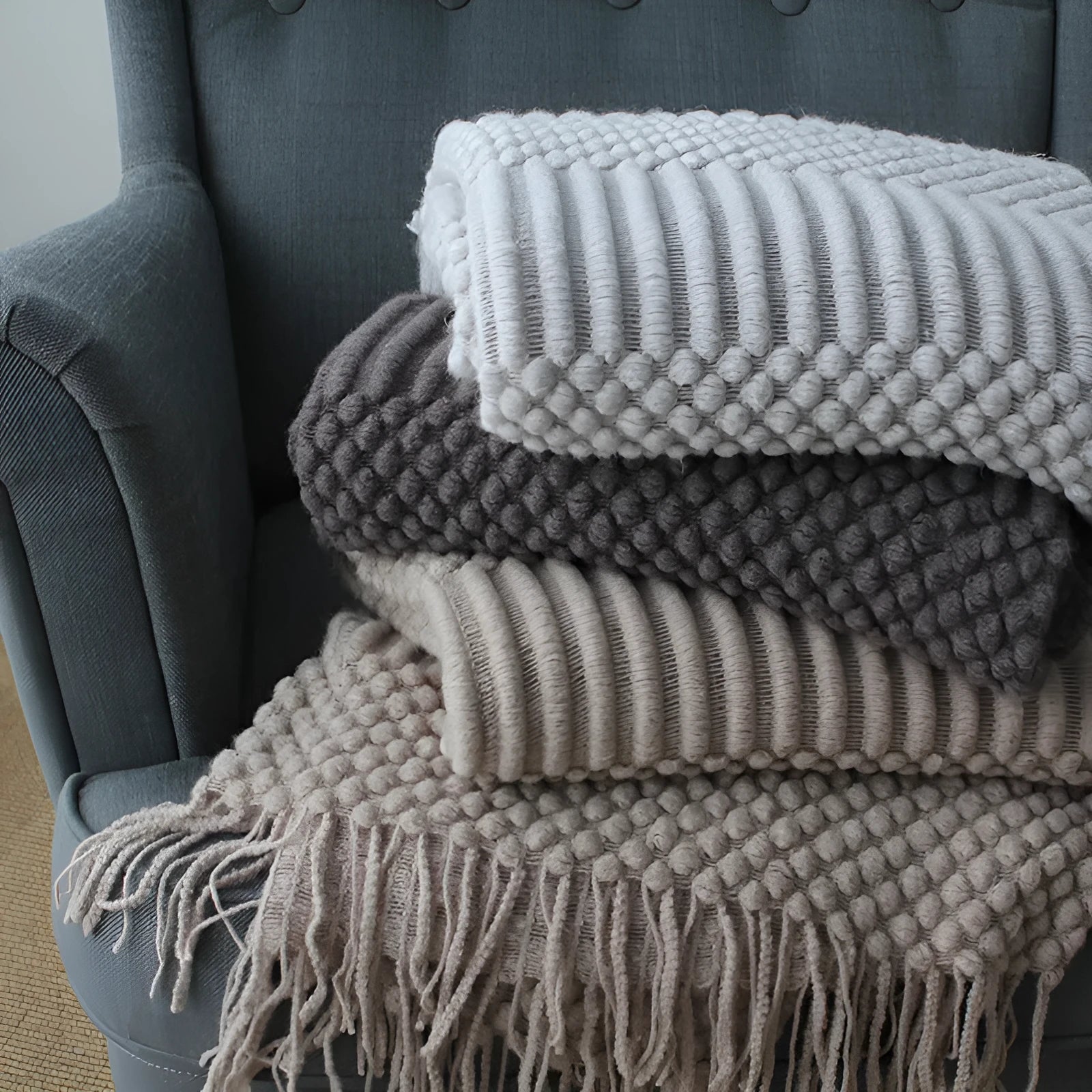 Small polyester blanket in dark grey, khaki or light grey colours measuring 127 by 170 centimetres