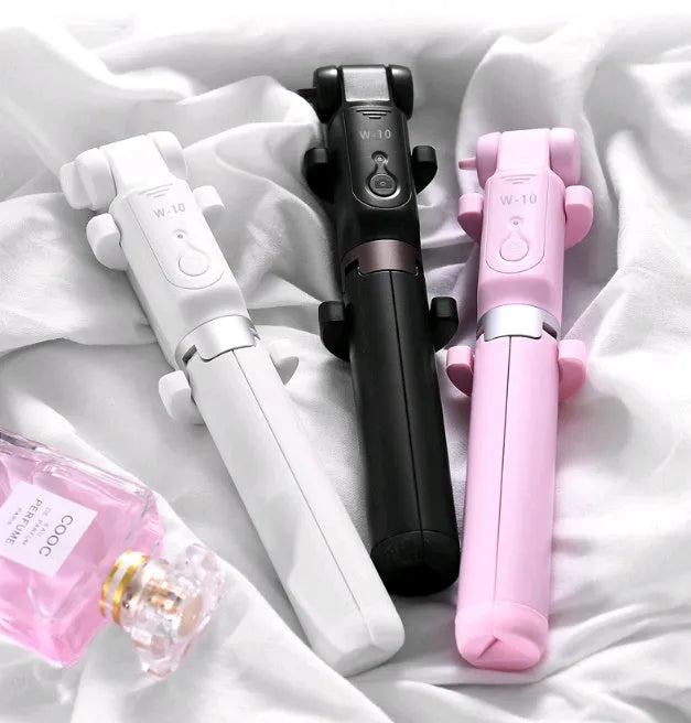 Aluminium Bluetooth selfie stick with tripod legs extended and wireless remote on a table
