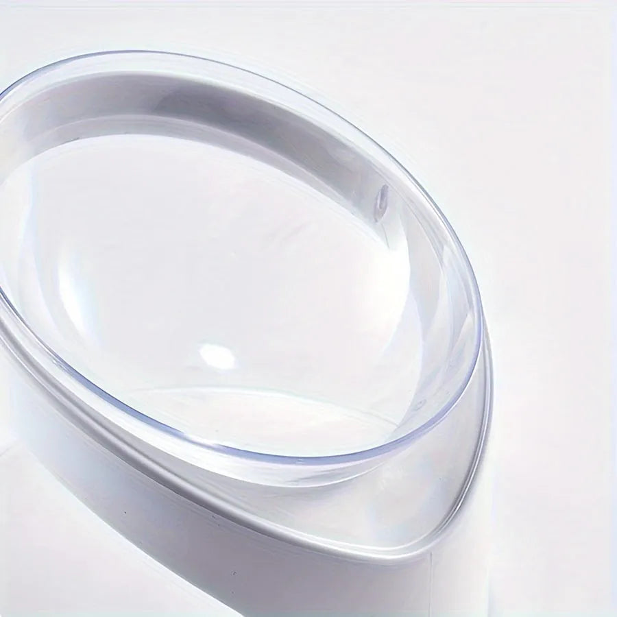 Clear plastic elevated cat food bowl with tilt design on white surface