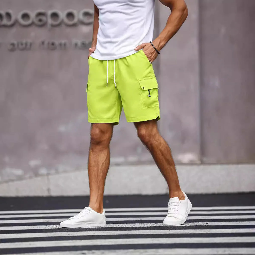 Man wearing loose fit army green straight leg workwear shorts made from cool silk cotton fabric.