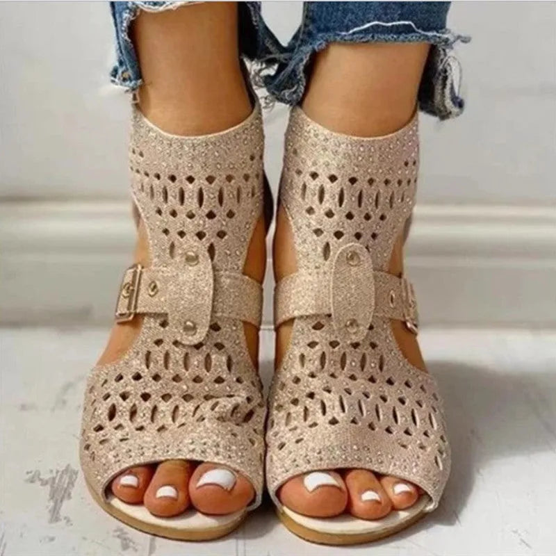 Women's beige flat sandals with fish mouth open toe and back zipper on a low wedge heel.
