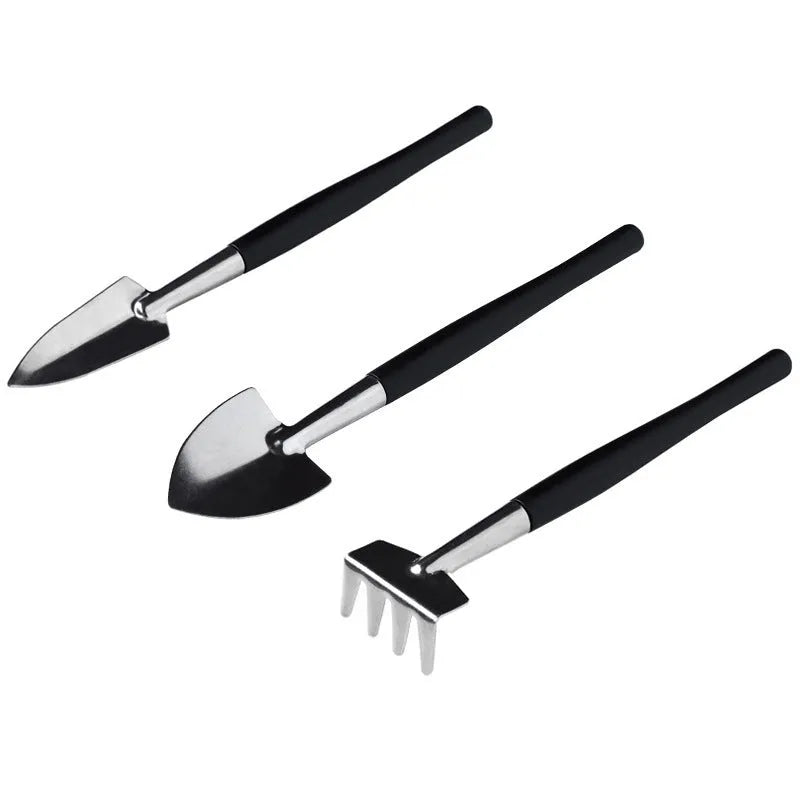 Miniature black plastic and metal garden tool set for succulents with shovel, rake, tweezers, watering bottle, and cushion.