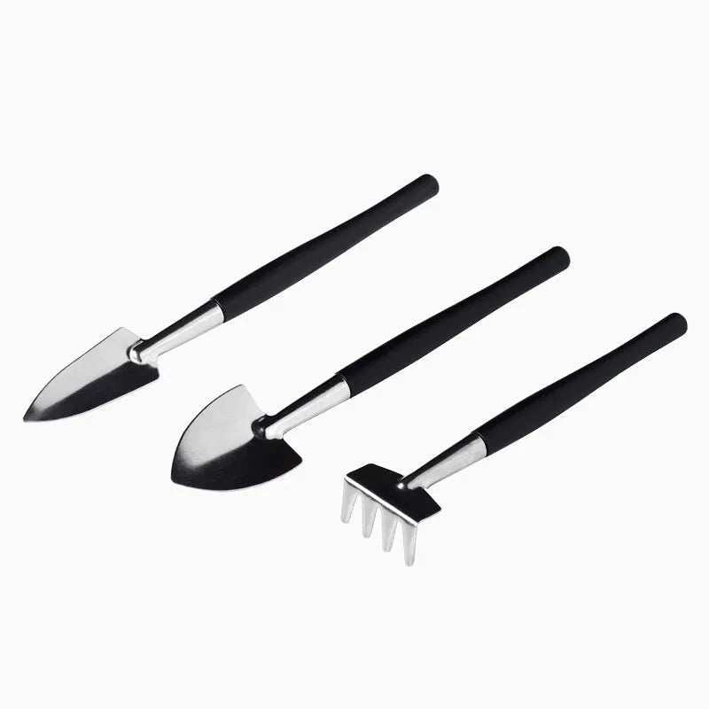 Miniature black plastic and metal garden tool set for succulents with shovel, rake, tweezers, watering bottle, and cushion.