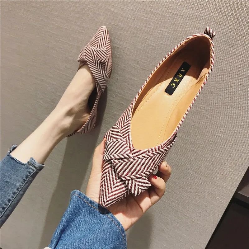 Women's black pointed toe cotton flats with a low flat heel and shallow mouth design on a white background.