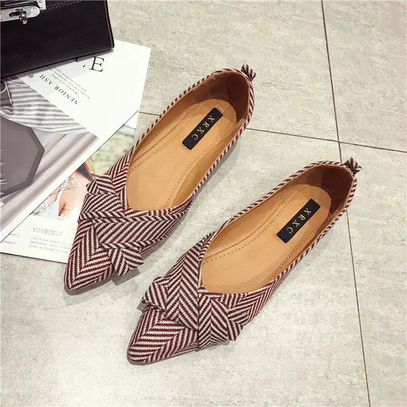 Women's black pointed toe cotton flats with a low flat heel and shallow mouth design on a white background.